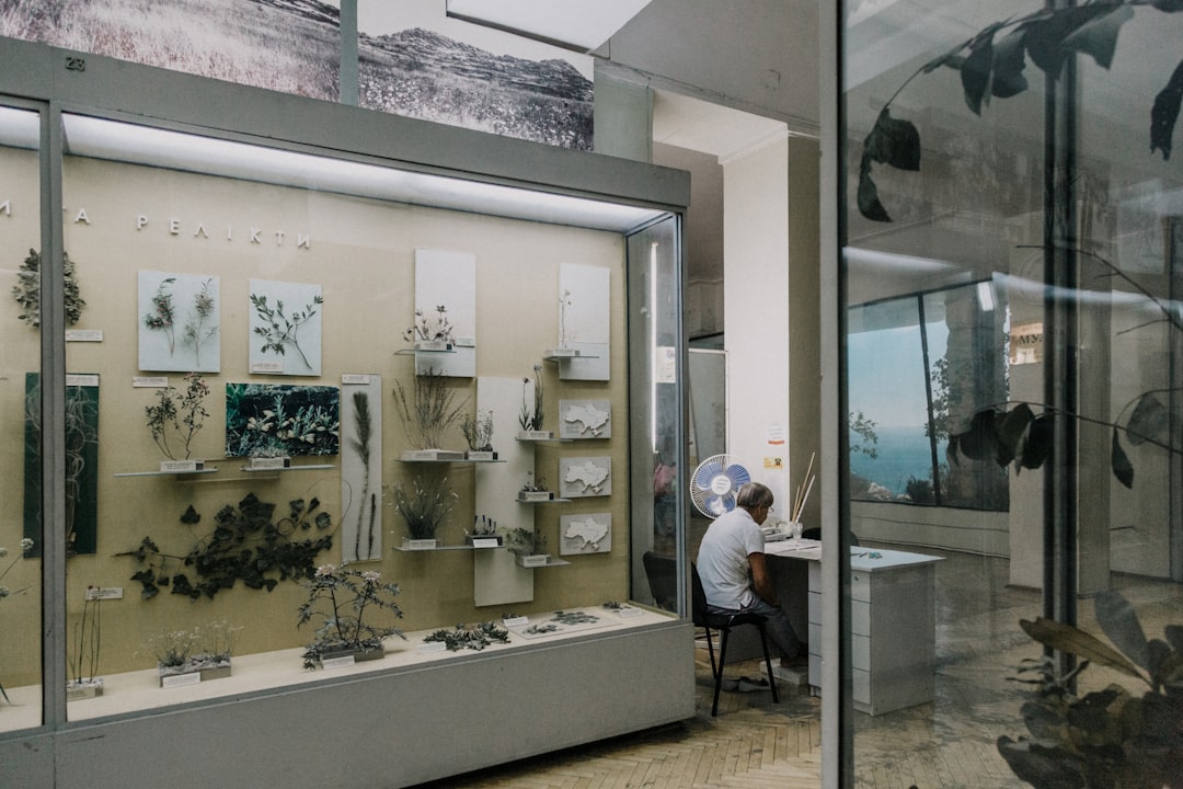 Un architecte et un client discutant de plans sur une grande table en bois, avec des échantillons de pierre naturelle posés dessus, dans un showroom lumineux.