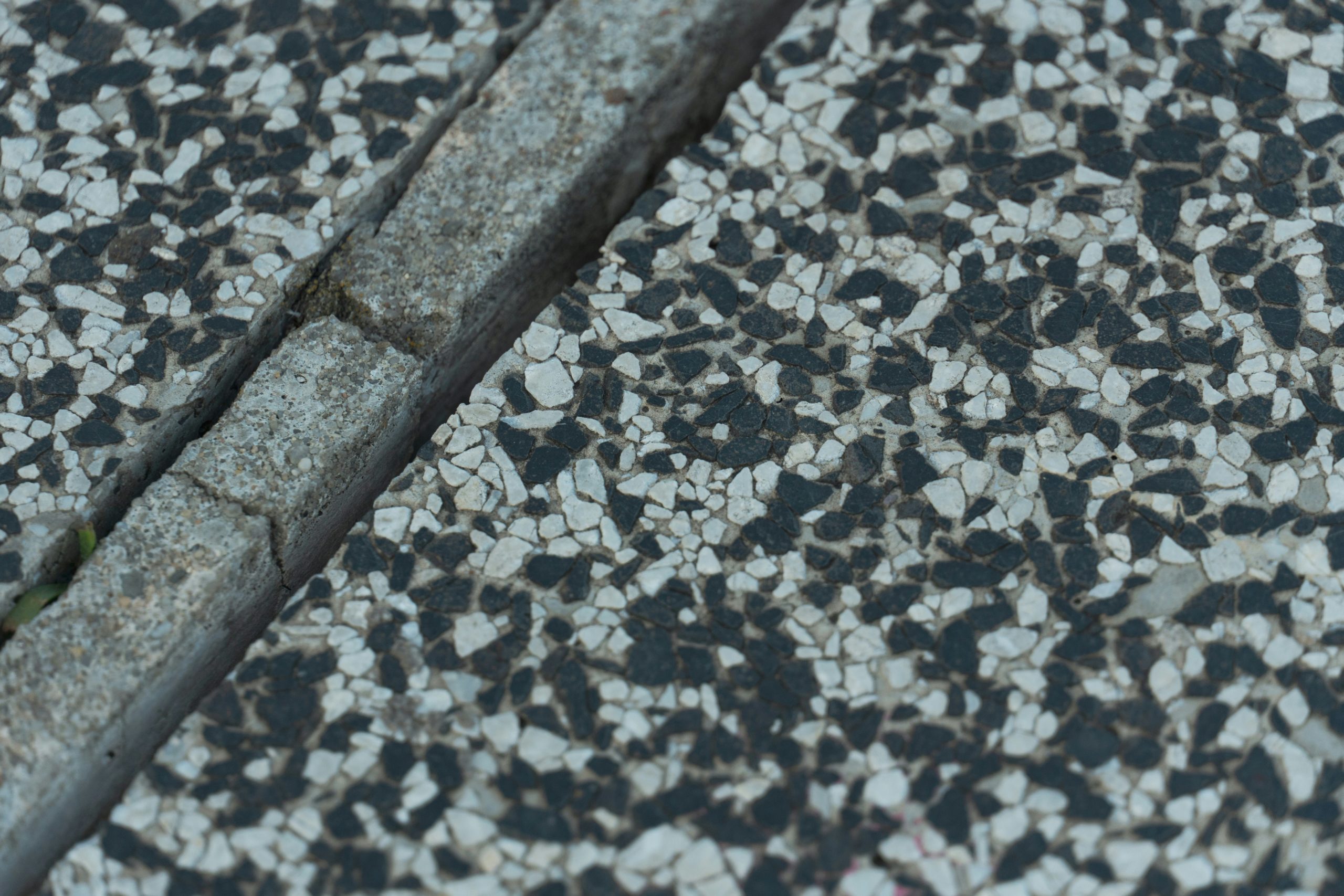 Close up texture comparison of polished granite, leather finish granite and honed marble slabs in a showroom setting