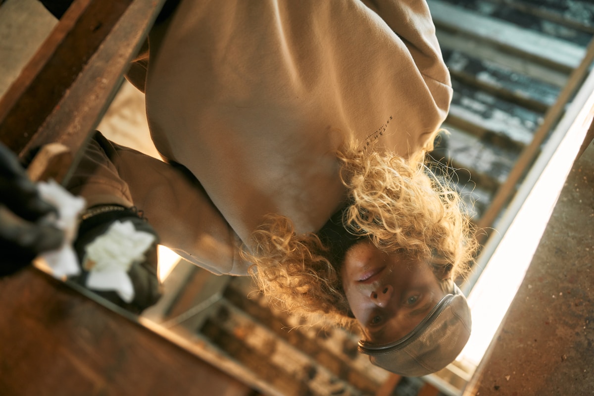 A person climbing up the side of a stair case