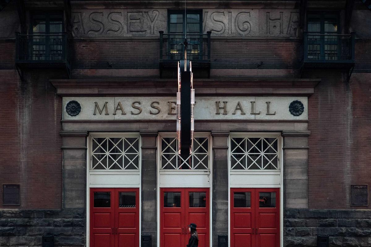 Ornate brick building with "Massey Hall" sign and red doors.