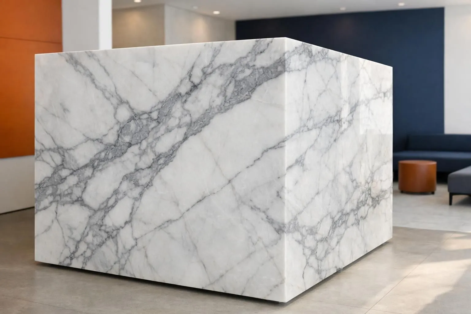 Close-up photograph of authentic white Statuario marble slab with distinctive bold grey veining patterns, displayed in luxury showroom setting with natural lighting highlighting the stone's translucent quality and premium texture