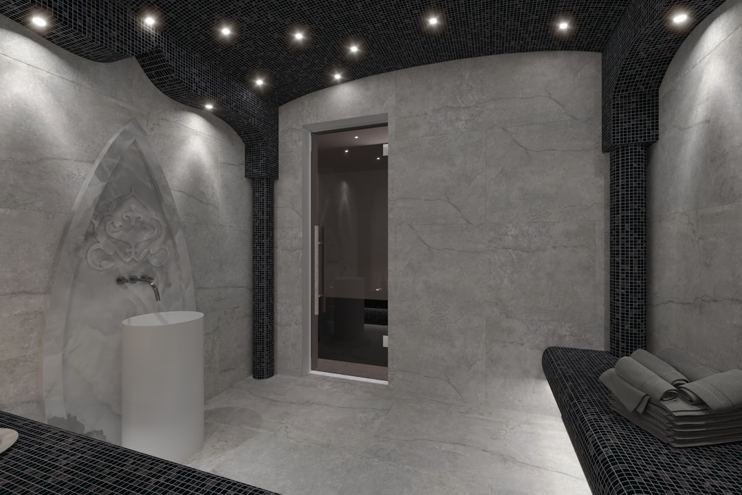 Salle de bain luxueuse avec des murs et un sol recouverts de grandes dalles de pierre naturelle grise, créant une ambiance sereine et élégante.