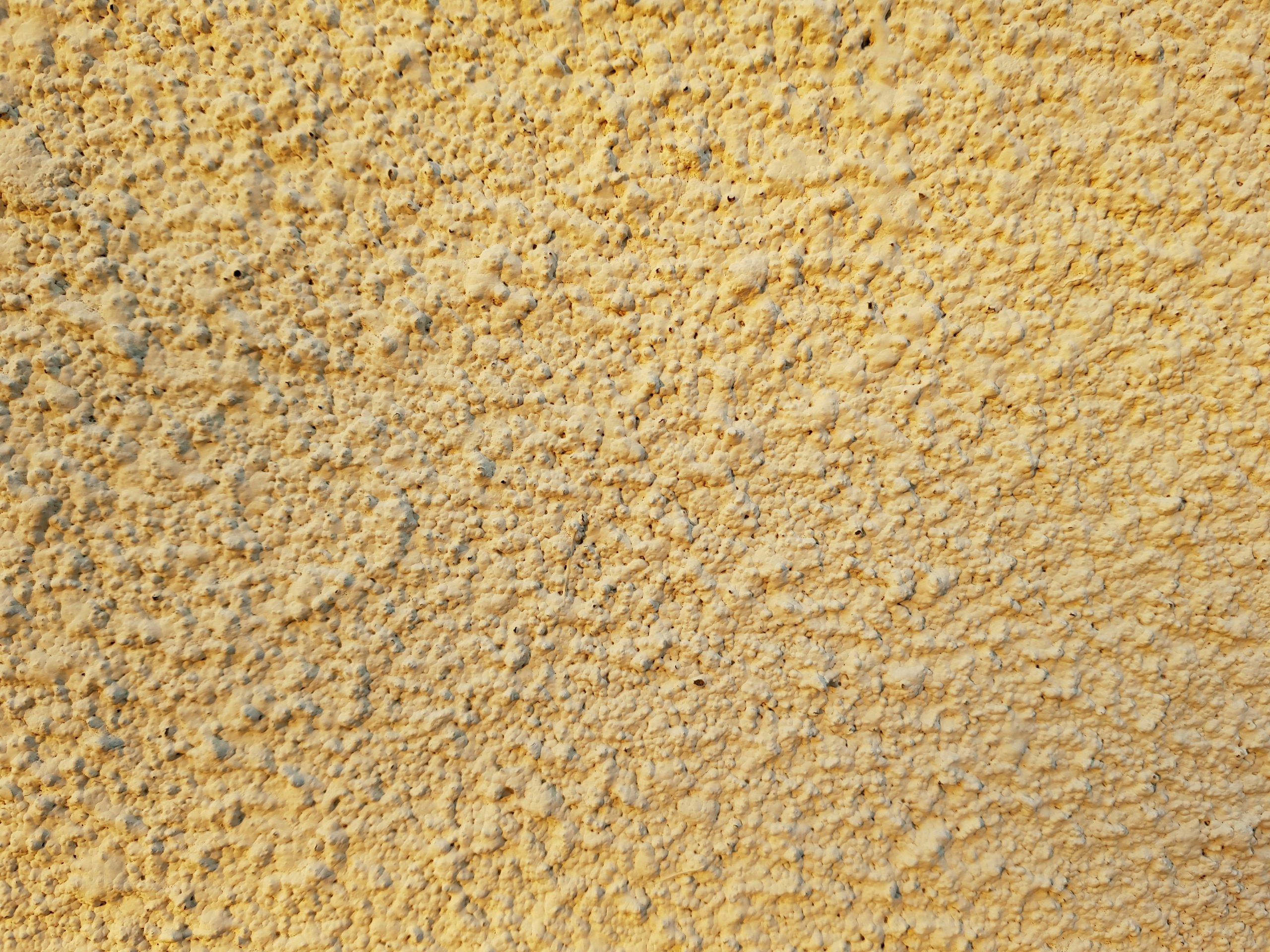 Close up texture of beige travertine stone showing natural pores and warm tones