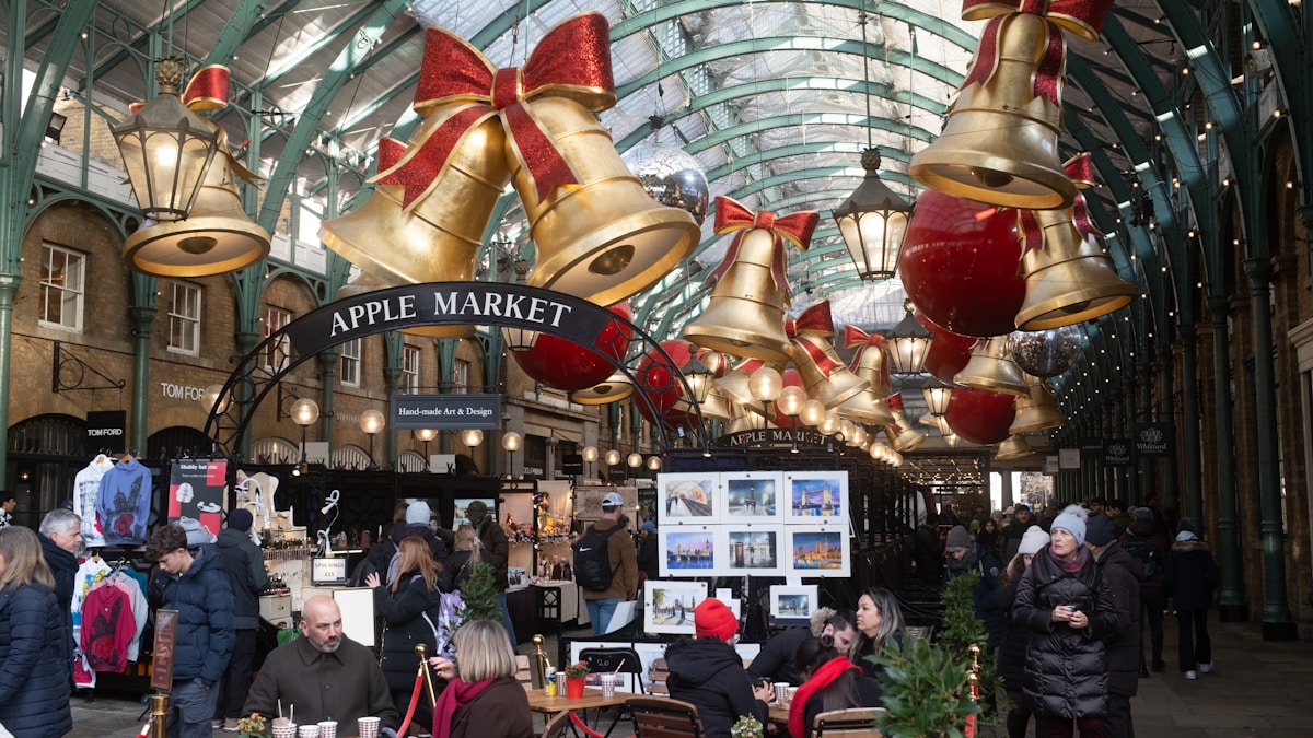 Marché de Noël animé avec décorations dorées et rouges.
