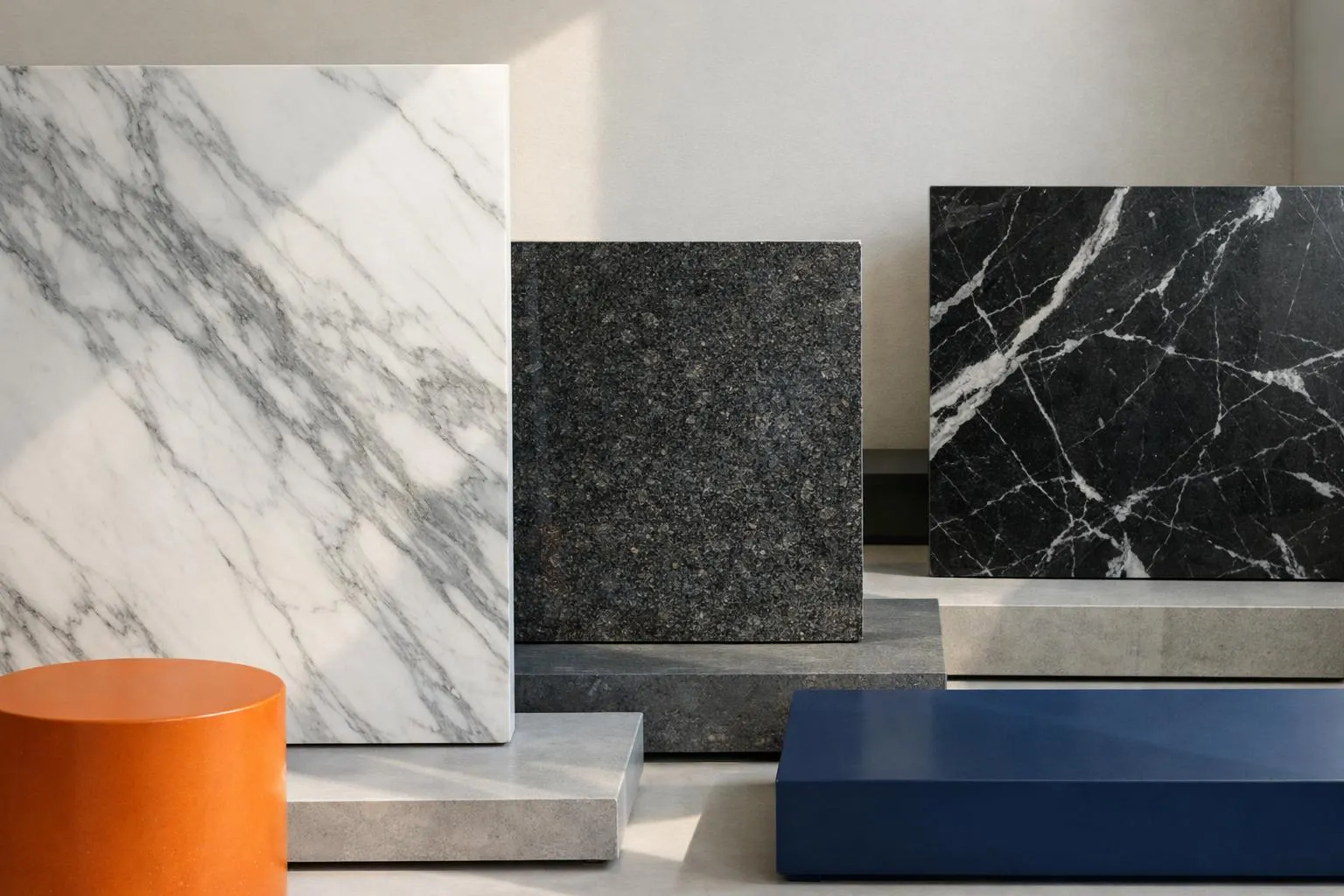 Close-up of polished natural stone slabs displayed in a Swiss showroom, showing distinct marble veining in white and grey tones alongside darker granite varieties, with natural light revealing the depth and translucency of the materials, architectural samples arranged against a neutral background