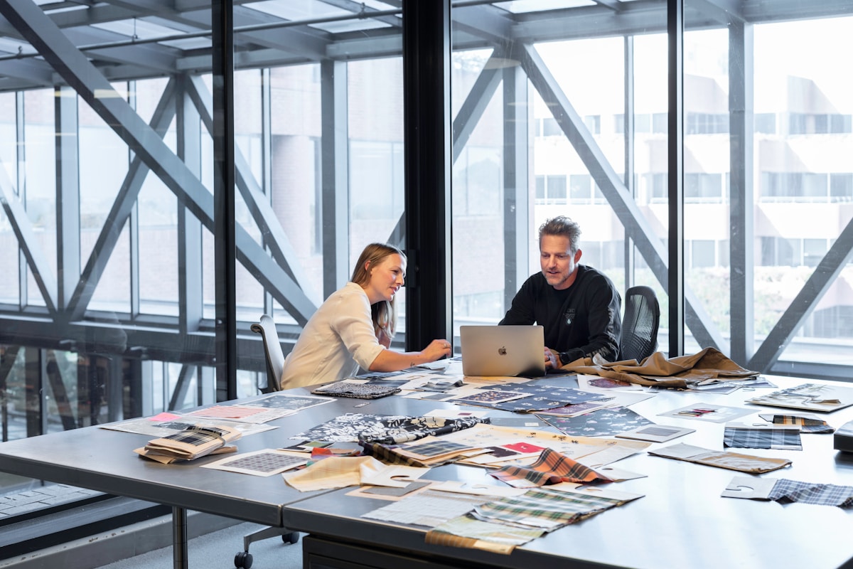 Deux personnes travaillant ensemble sur un projet créatif dans un bureau moderne.