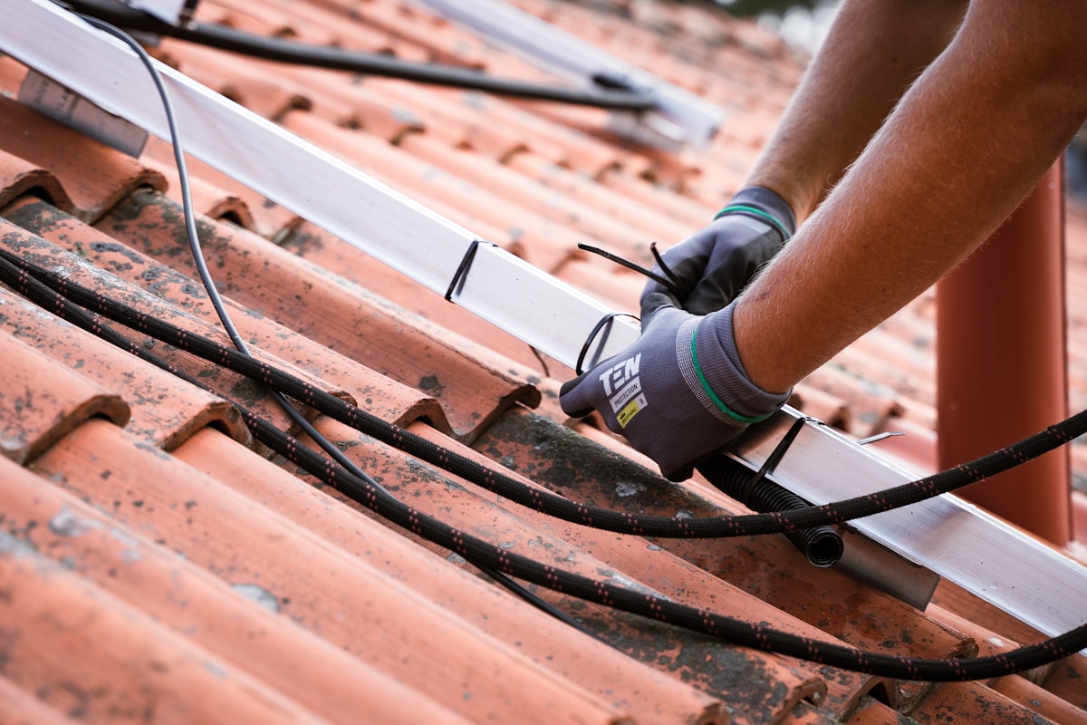 Réparation de toiture avec des tuiles en céramique et outils de construction.