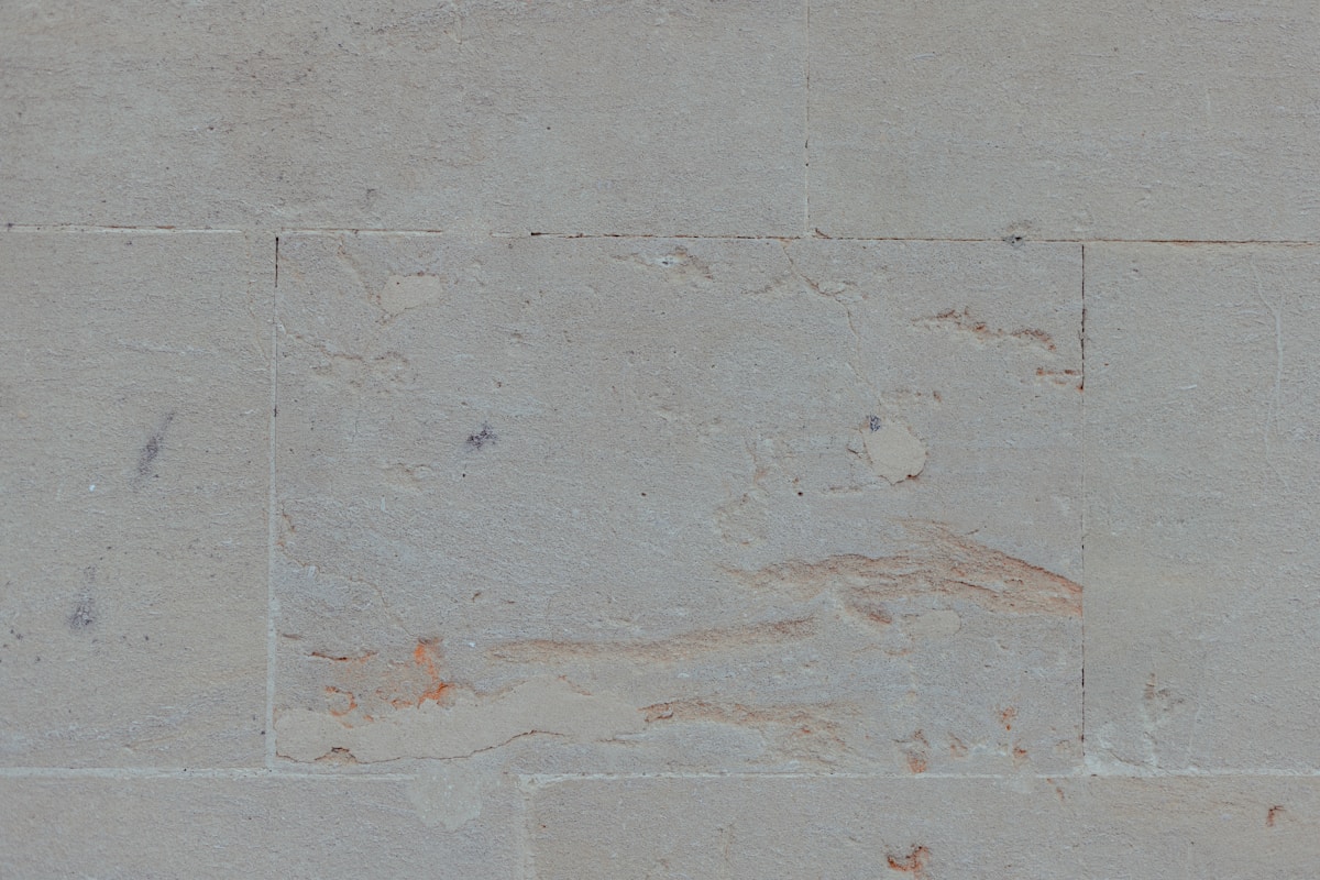 Mur de béton gris avec des fissures et des taches.