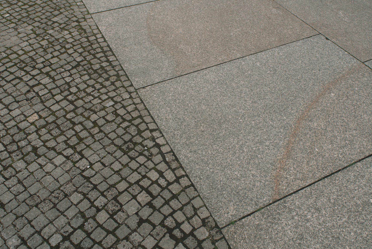 Pavés de pierre grise et granit poli, contraste de textures.