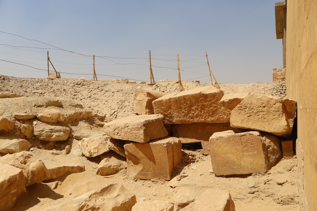 Ruines de pierre dans un paysage désertique avec des poteaux.
