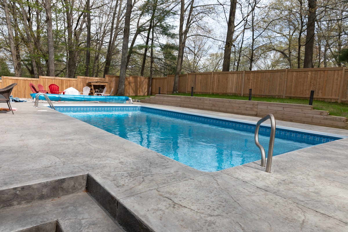 Piscine extérieure entourée d'arbres dans un jardin privé.