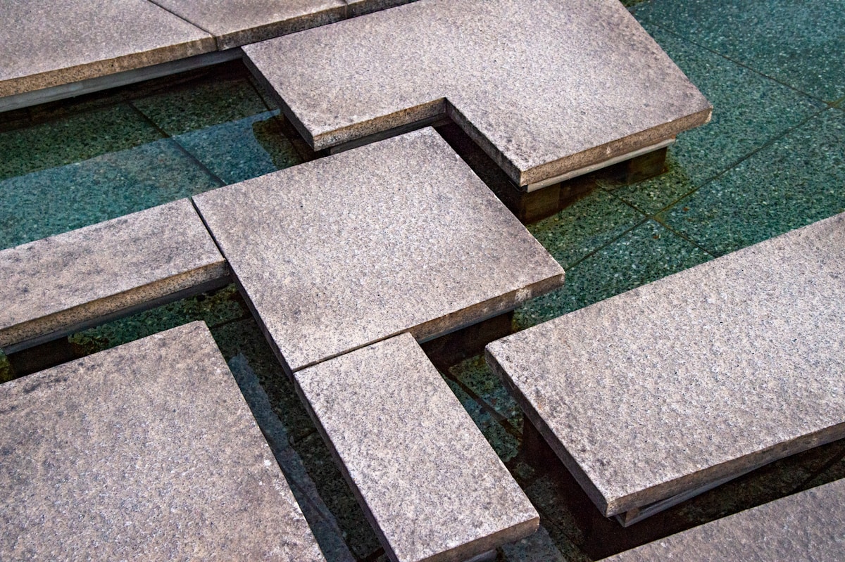 Carreaux de granit gris sur sol en gazon vert.