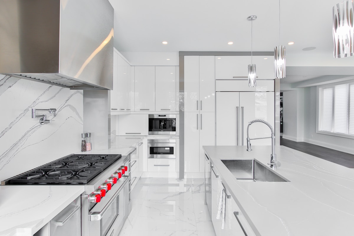 Cuisine moderne, épurée, avec électroménagers en acier inoxydable.