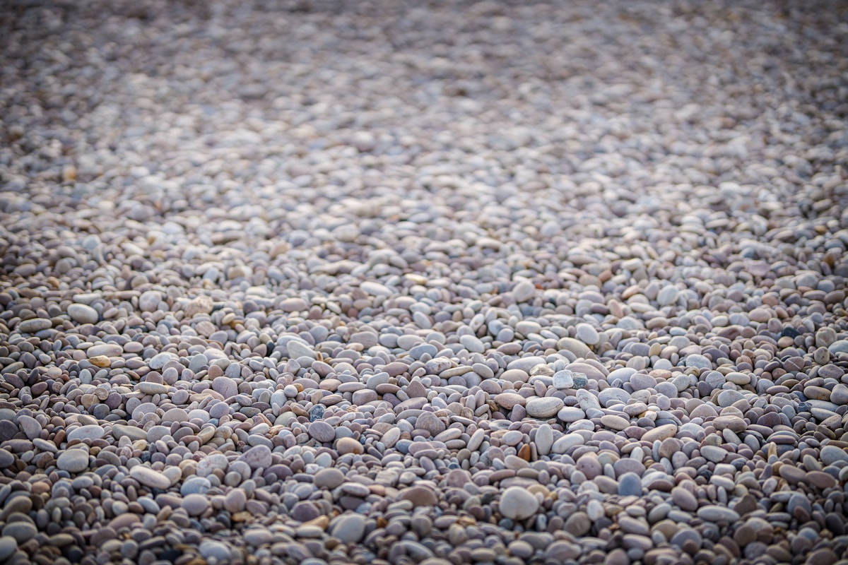 Tapis de galets gris et beiges sur le sol.