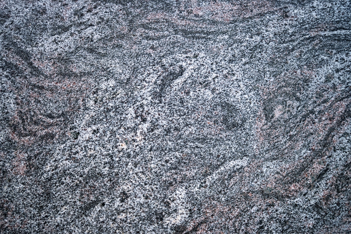 Texture de granit gris foncé avec des motifs irréguliers.