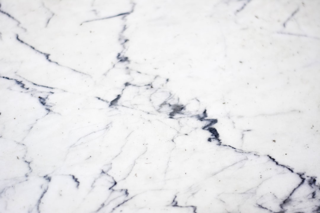 "Peinture abstraite noir et blanc évoquant la texture du marbre de pierre."