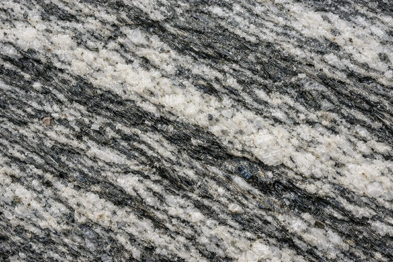 Texture de granit gris et noir avec des veines et des motifs uniques.