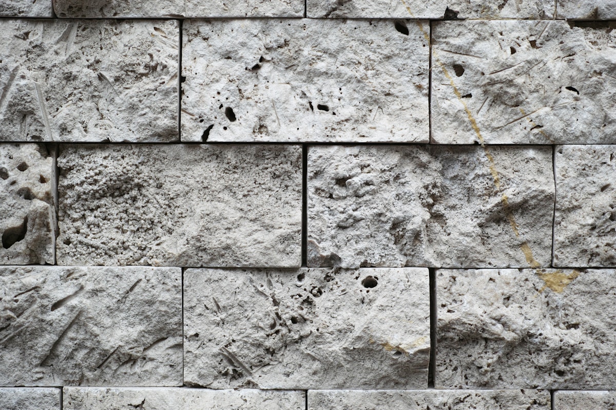 Mur de pierre grise texturé et irrégulier.