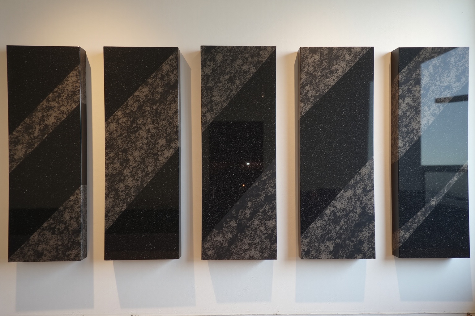 Panneaux de granit noir et gris disposés en rangée.