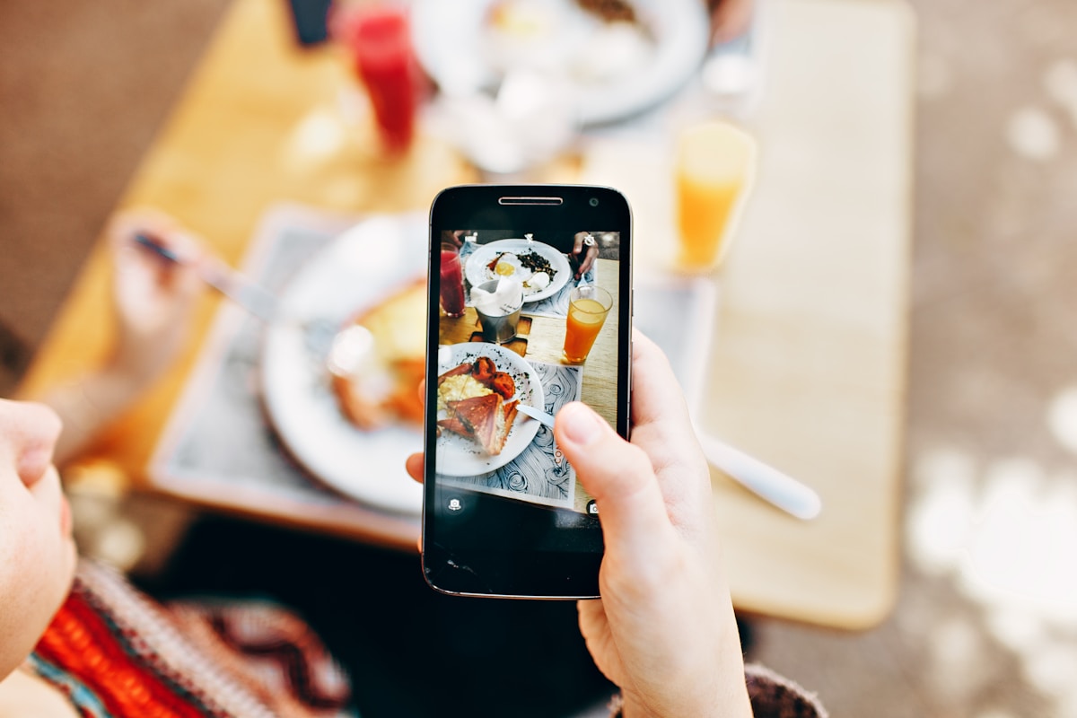 Personne prenant une photo de son petit-déjeuner sur un smartphone.