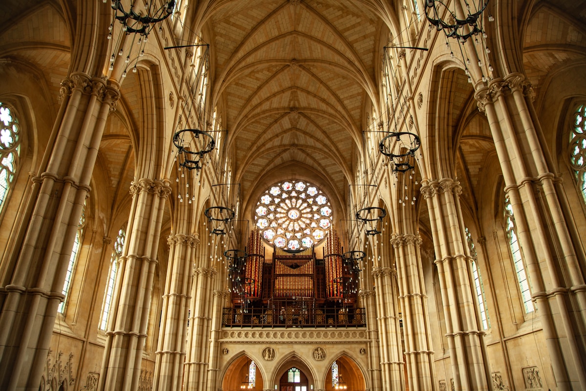Cathédrale gothique avec arches, vitraux et orgue imposants.