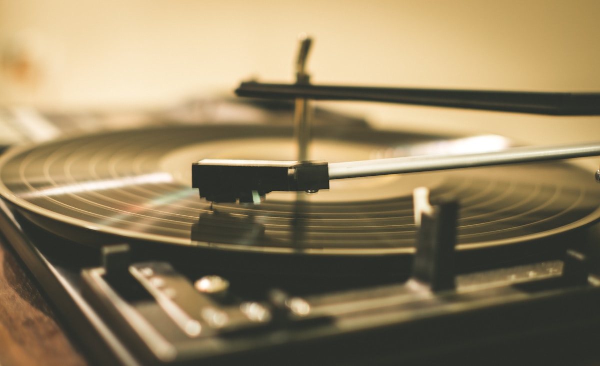 Tourne-disque vintage avec aiguille et disque vinyle en rotation.