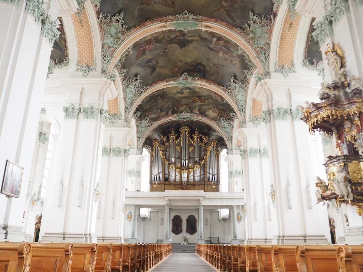 Intérieur d'une église baroque ornée de fresques et d'un magnifique orgue.