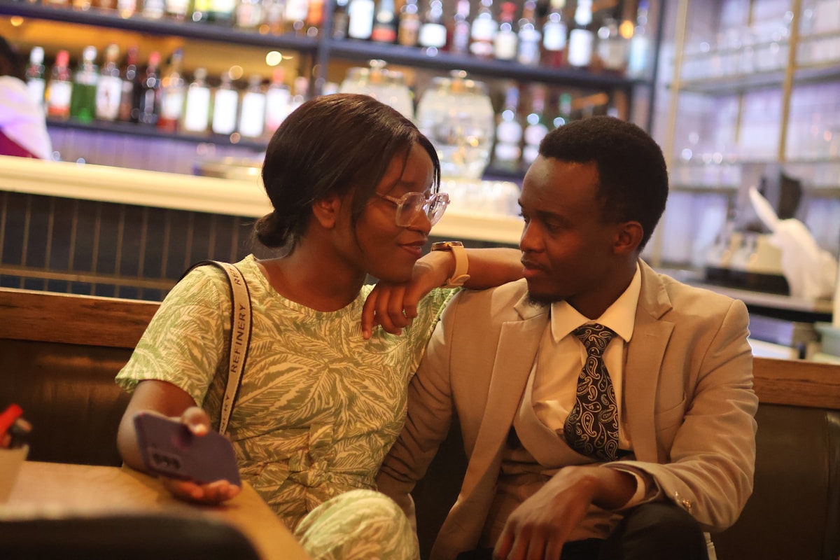 Couple élégant assis dans un bar, discutant et partageant un moment intime.