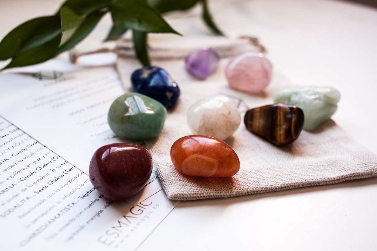 Assortiment de pierres précieuses colorées sur un texte manuscrit.