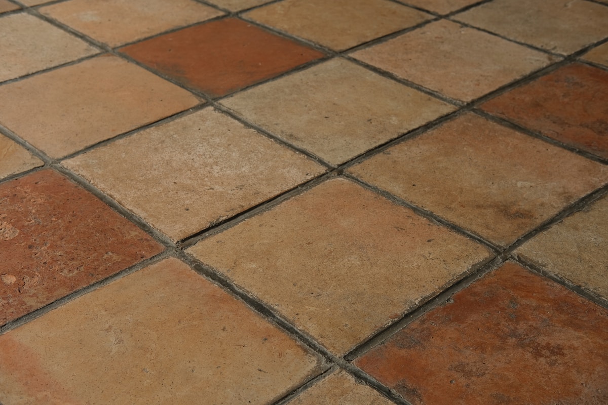 Carreaux de céramique carrés de couleurs beige et rouges.