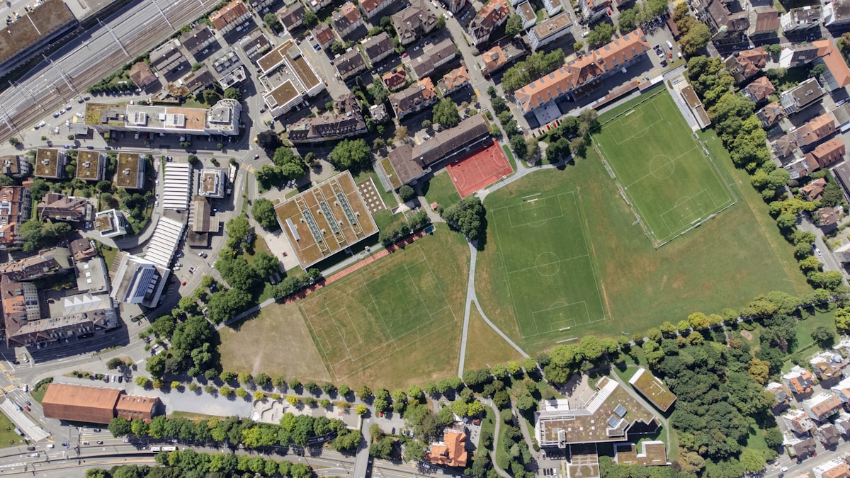 Vue aérienne d'un quartier urbain avec des bâtiments, des rues et des espaces verts.