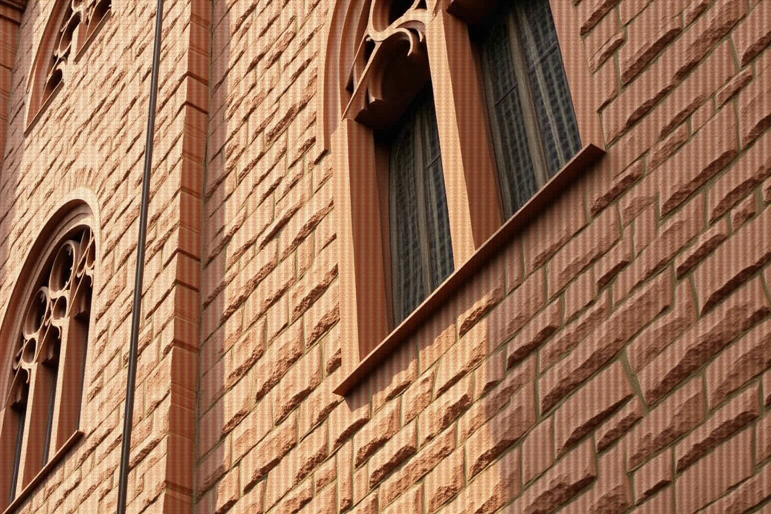 Façade de brique rouge avec des motifs architecturaux complexes.
