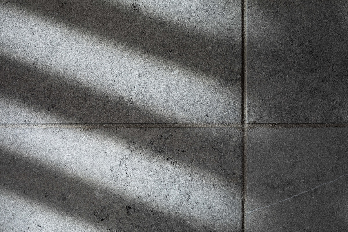 Texture de béton gris avec des ombres projetées.