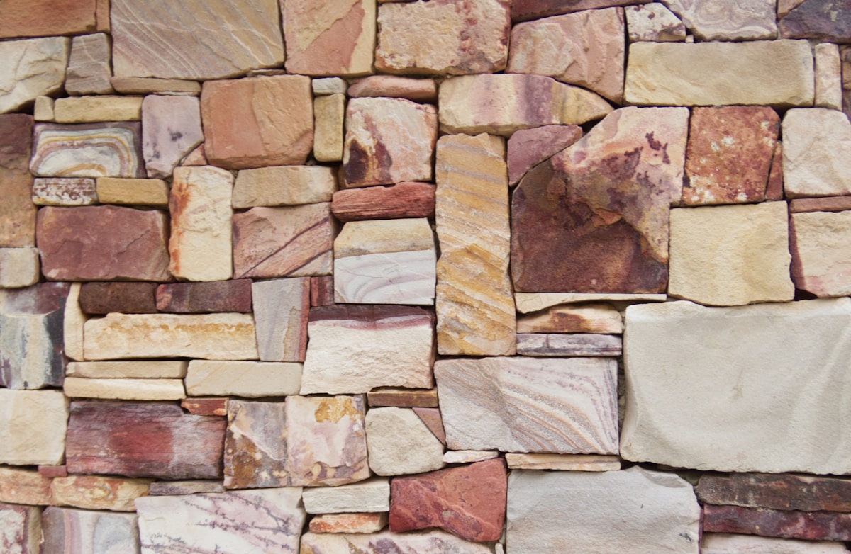 Mur de pierres naturelles de différentes couleurs et textures.