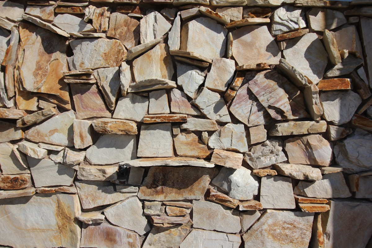 Mur de pierres naturelles de différentes formes et couleurs.