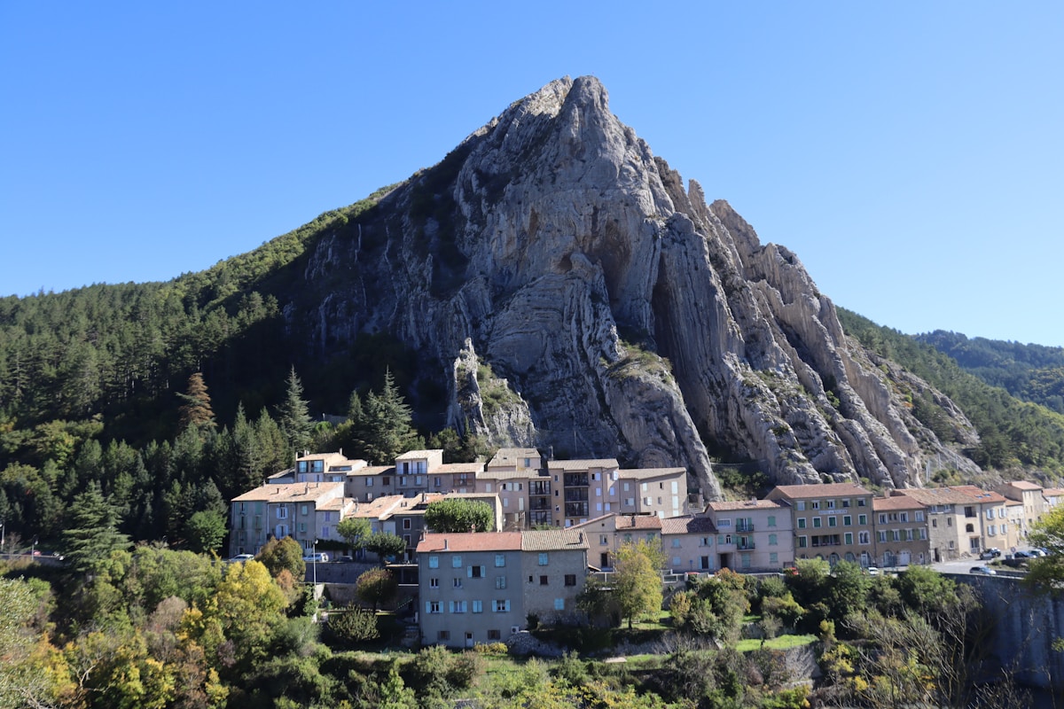 Village pittoresque au pied d'une montagne escarpée.