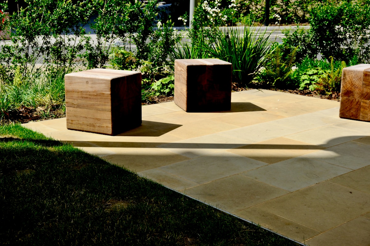 Jardin paysager avec dalles en pierre et blocs de bois.