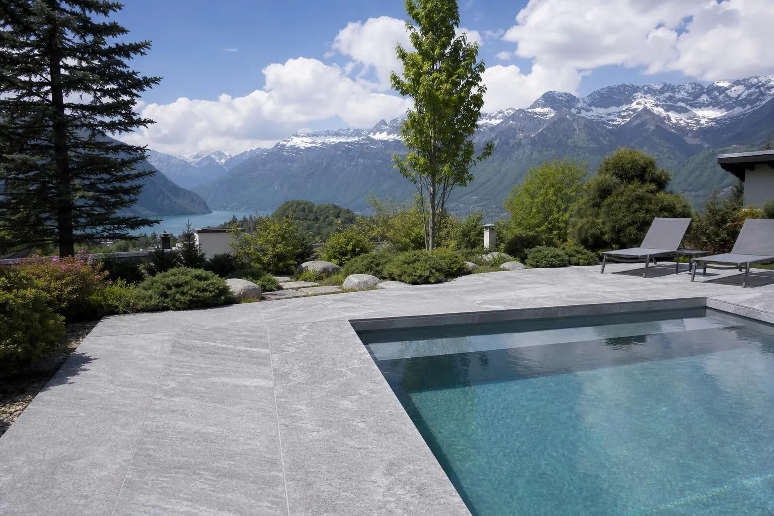 Piscine extérieure avec vue panoramique sur les montagnes enneigées.