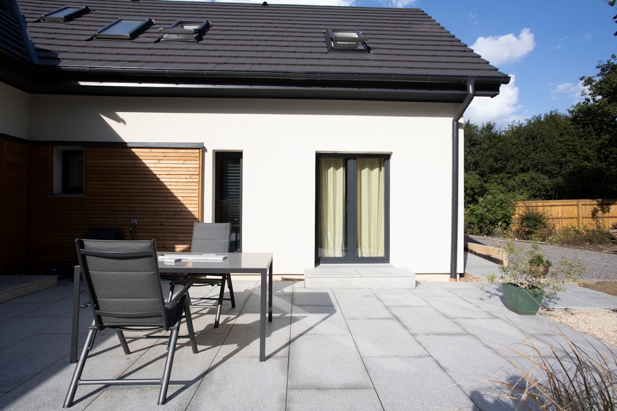 Maison moderne avec terrasse et mobilier de jardin.