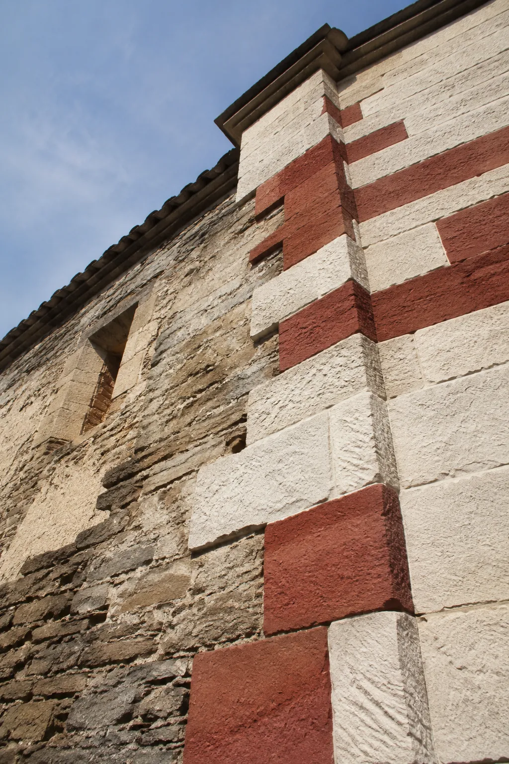 Mur de pierre et de brique avec motifs géométriques.